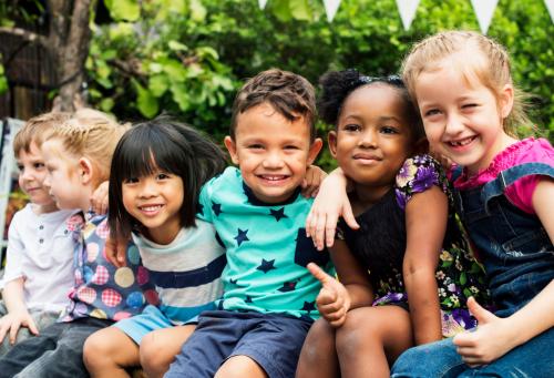 group-kindergarten-kids-friends-arm-around-sitting-smiling-fun